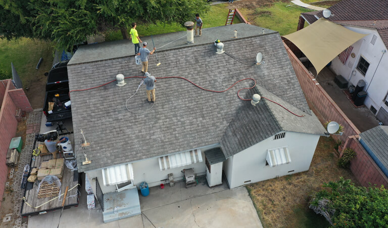 A group of men working on the roof of a house.