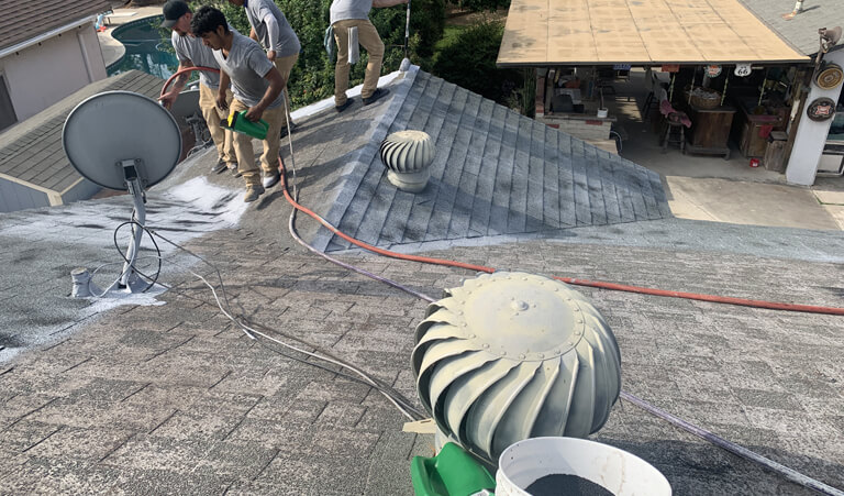 A group of men working on the roof of a house.