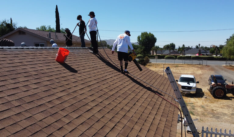 A group of three people standing on top of a roof.