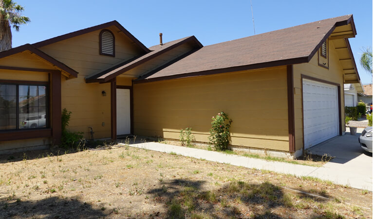 A brown house with a white door and windows.