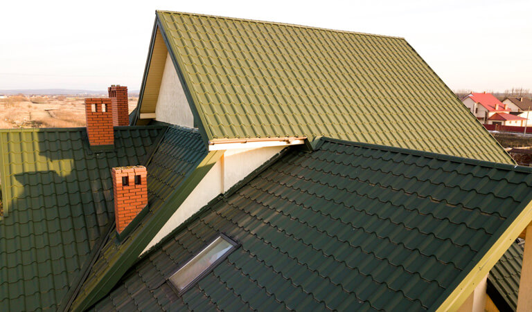 A green roof with a brick chimney and a skylight.