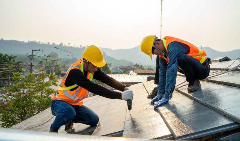 A group of men working on the roof of a building.