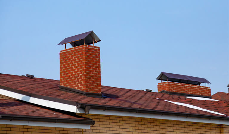 A brick building with two chimneys on top of it.