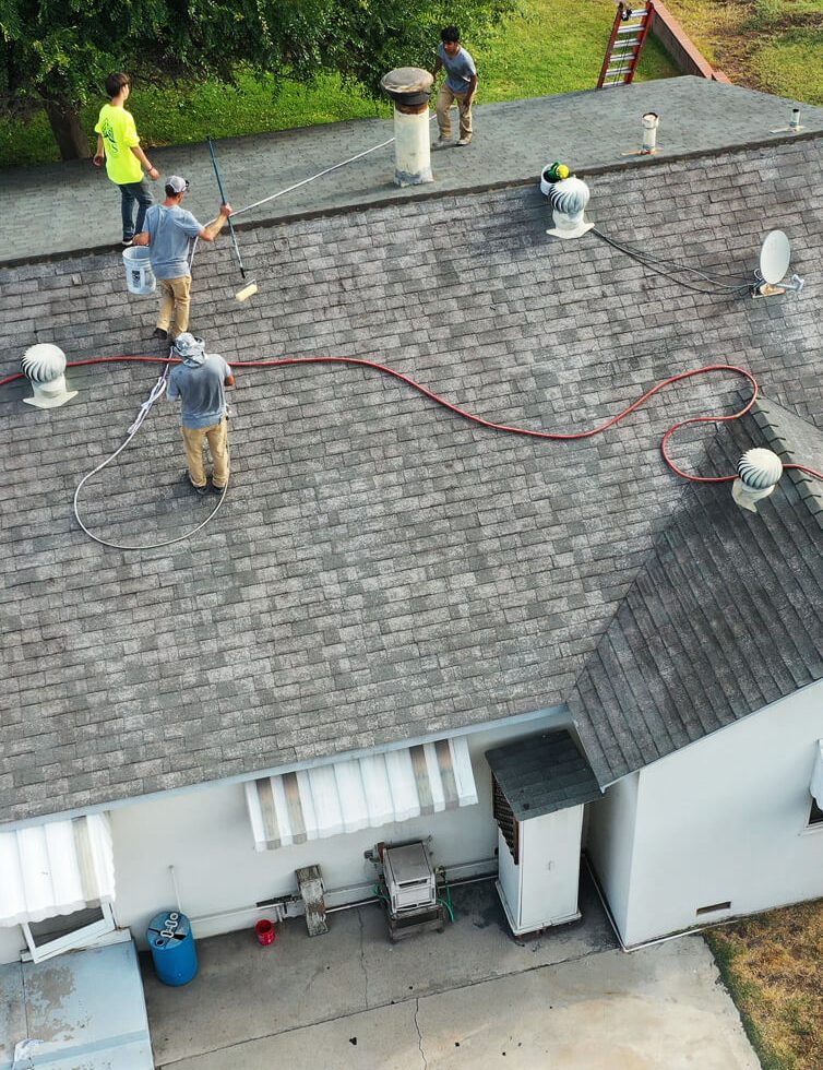 A group of men working on the roof of a house.